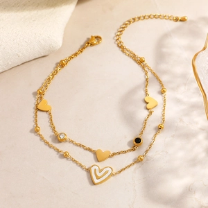 Tobillera de doble capa en acero inoxidable dorado con dijes de corazón y esmalte blanco