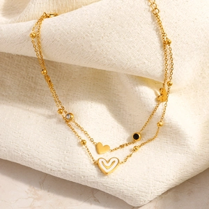 Tobillera de doble capa en acero inoxidable dorado con dijes de corazón y esmalte blanco