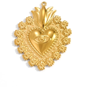Detailed macro view of a golden sacred heart pendant with eye motif and floral relief details