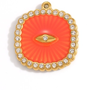 Détail d'un pendentif œil de protection plaqué or 18 carats avec émail orange et cristaux
