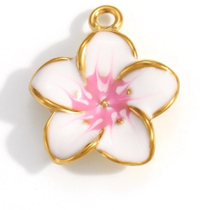 Macro view of white enamel flower pendant with pink gradient center and gold plating