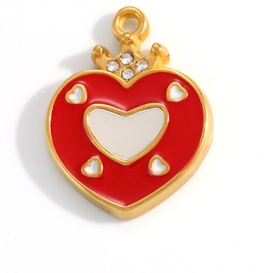 Macro shot of gold-plated red heart pendant with crown design and sparkling rhinestones