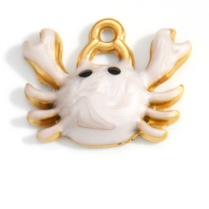 Detailed macro view of crab shaped white enamel charm with 18K gold plating for DIY jewelry