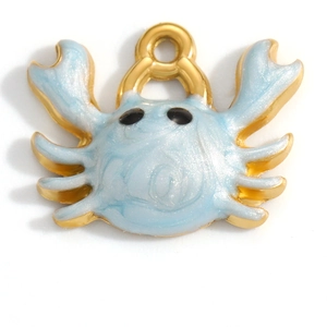Close-up of golden crab charm with light blue enamel inlay and glitter for DIY jewelry