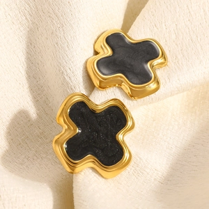 Détail des boucles d'oreilles croix plaquées or 18 carats avec incrustation noire