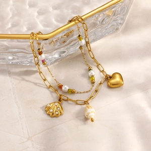 Détail du bracelet double couche plaqué or 18 carats avec coquillages, perles et cœurs