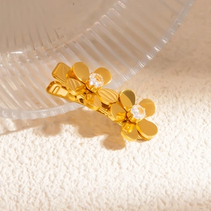 Detailed macro view of a gold flower hair clip with sparkling crystals and a shiny finish