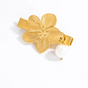 Detailed macro view of a 18k gold-plated flower hair clip featuring a white pearl pendant