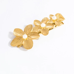 Detail of 18k gold plated flower hair clip with white pearls and textured petals
