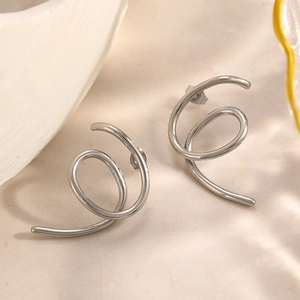 Minimalist silver spiral hoop earrings with dual-ring wrap design on stone surface