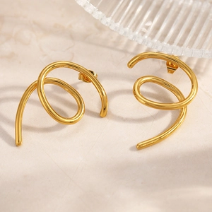 Detailed macro shot of 18k gold plated spiral earrings with polished geometric texture