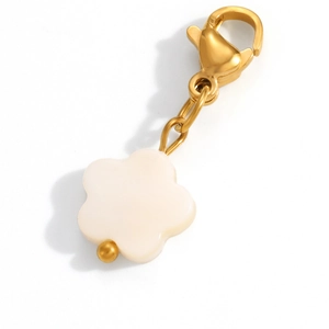 Close-up of a white five-petal flower charm with a golden lobster clasp and smooth finish