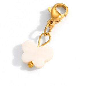 Detailed view of a creamy white butterfly pendant with a golden lobster clasp on white background