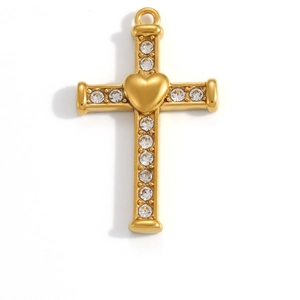 Détail d'un pendentif croix doré avec un cœur central et des strass incrustés brillants