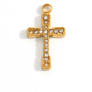 Gros plan d'un pendentif croix dorée avec des zircons scintillants sur fond blanc