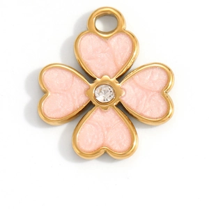 Détail macro d'un pendentif trèfle rose avec bordure dorée et strass scintillant