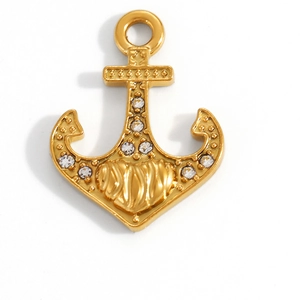 Detailed macro view of a gold anchor pendant with sparkling white crystals and ocean texture