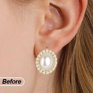 Macro shot of elegant oval pearl earrings with gold base worn by a model in detail