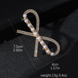 Elegant gold bow hair clip with pearls and rhinestones on black background, 7.5cm size