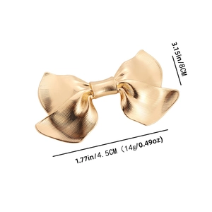 Elegant gold bow-shaped metal hair clip with vertical striped texture and spring design