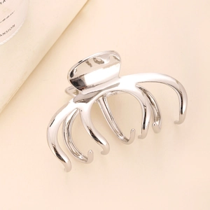Minimalist silver metal hair claw clip with sleek pumpkin design on a soft beige background