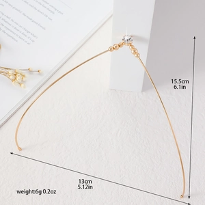 Dettaglio di un elegante cerchietto dorato con perle e pietre preziose scintillanti