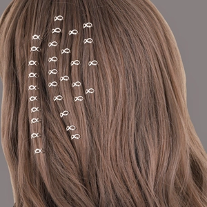 Infinity shaped silver hair clips for braids and dreadlocks on long brown hair