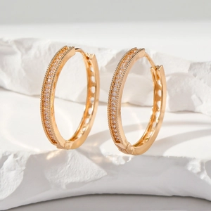 Elegant gold-plated hoop earrings with double-row zircon inlay on a white pedestal