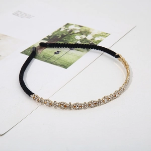 Fashionable gold alloy headband with white rhinestones on a stylish magazine background