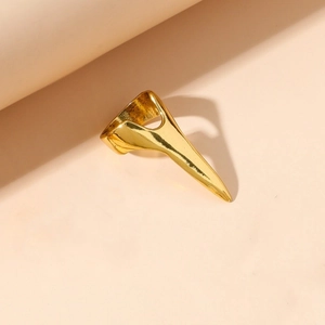 Macro-detail van een gouden Wolverine-klauwring met creatief geometrisch pantserontwerp
