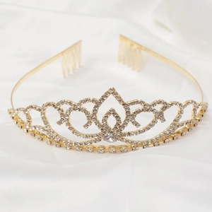 Close-up detail of golden bridal tiara with sparkling rhinestones on white silk