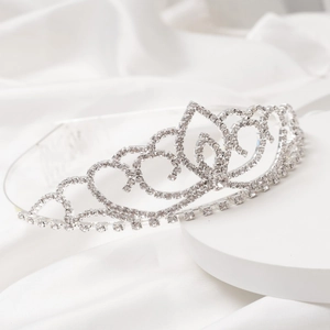Elegant silver bridal tiara with sparkling rhinestones on a white satin display background