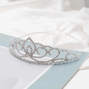Elegant silver bridal tiara with sparkling crystal hearts on silky white satin background