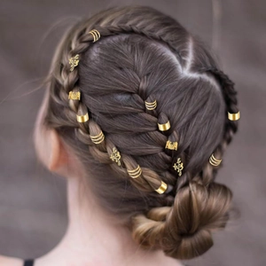 Vue détaillée de bagues à cheveux dorées et breloques feuilles sur tresse complexe