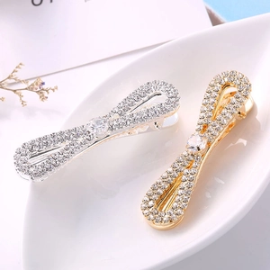 Elegante set di fermagli per capelli con strass oro e argento in un vassoio decorativo