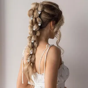 Détail d'anneaux de cheveux papillon blancs sur des tresses pour un style féerique