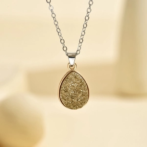 Gros plan d'un pendentif en forme de goutte avec cadre doré et texture cristal