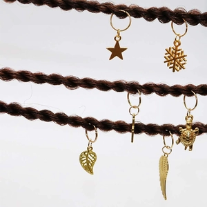 Golden hair charms including stars and feathers on braids for DIY hair styling