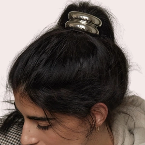 Close-up of a minimalist silver metallic hair tie ring on a sleek high ponytail hairstyle