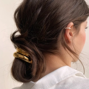 Polished gold alloy hair tie loop for ponytail styling shown on model in modern style