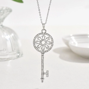 Collana classica con pendente a chiave d'argento e cristalli lucenti su sfondo fine