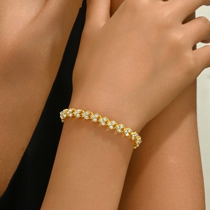 Elegant gold bracelet with clover-shaped crystal links on wrist for women's accessory