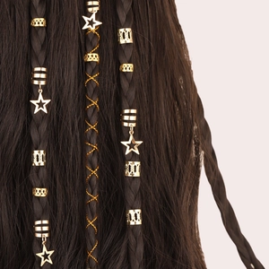 Close-up of golden star charms and hollow metal rings on braided hair accessories