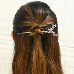 Silver branch hair pin with purple gemstone detail worn in a traditional bun hairstyle