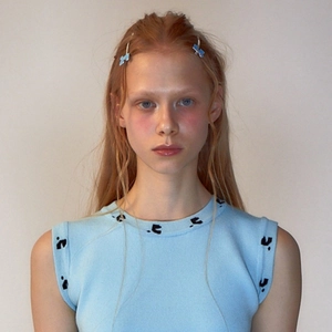 Close-up of light blue butterfly hair clips worn with a matching knit sleeveless top