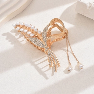 Detailed close-up of golden lily of the valley hair claw with pearls and rhinestones
