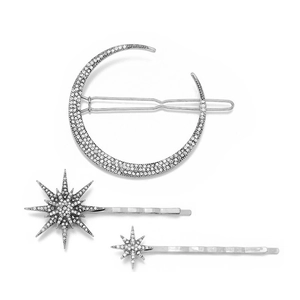 Detail of silver hair clips set with moon and star shapes and shimmering crystals