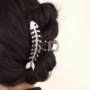Silver metal fishbone hair claw clip for women's hairstyles on beige background