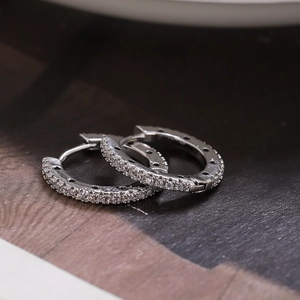 Elegant geometric silver huggie earrings with pavé set zircon stones for a minimalist look