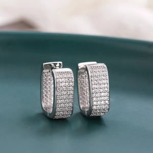 Macro detail of silver rectangle hoop earrings with pavé micro-set cubic zirconia stones